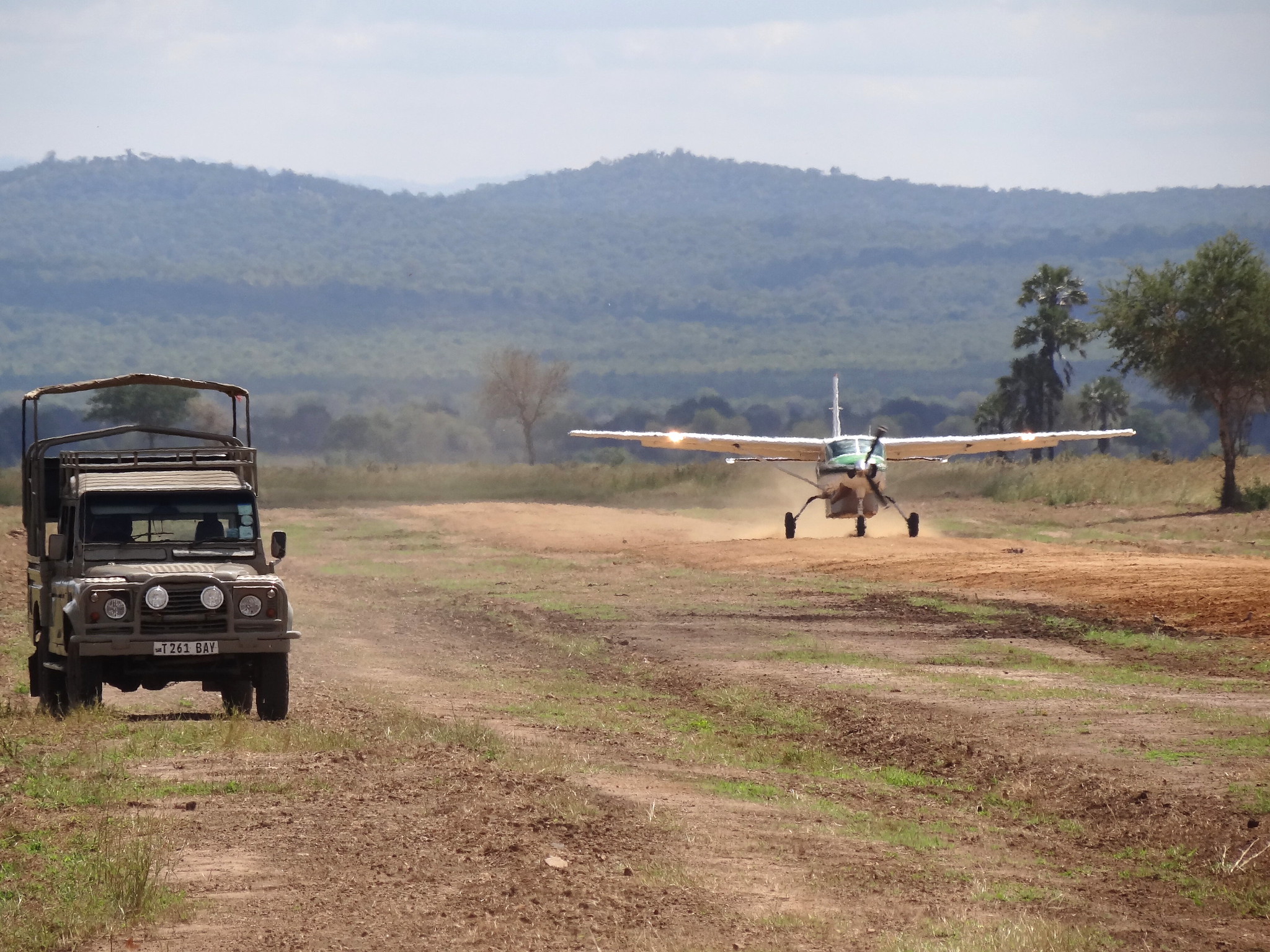A Cessna landing alongside a Land Rover in Mikumi National Park, Tanzania. Photograph by Adam Jones, 2013. CC BY-SA 2.0.
